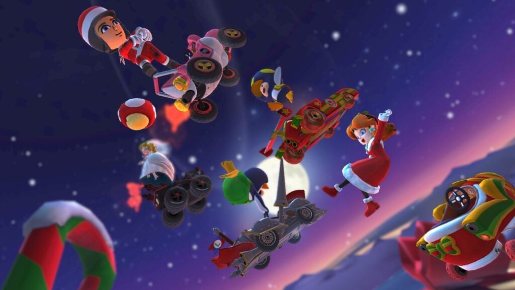 La imagen destacada de nuestro artículo sobre las mejores actualizaciones navideñas de Android con una imagen promocional de Mario Kart Tour.  En la imagen, una variedad de personajes de Mario Kart como Daisy salen volando de sus karts hacia el cielo nocturno.